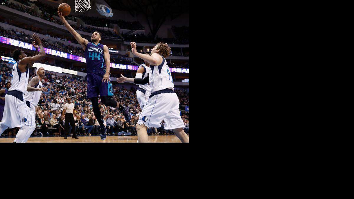 
Hornets forward Jeff Taylor shoots in front of Mavericks forward Al-Farouq Aminu, left, forward Charlie Villanueva, back left, and forward Dirk Nowitzki during the first half in Dallas on Sunday night.
