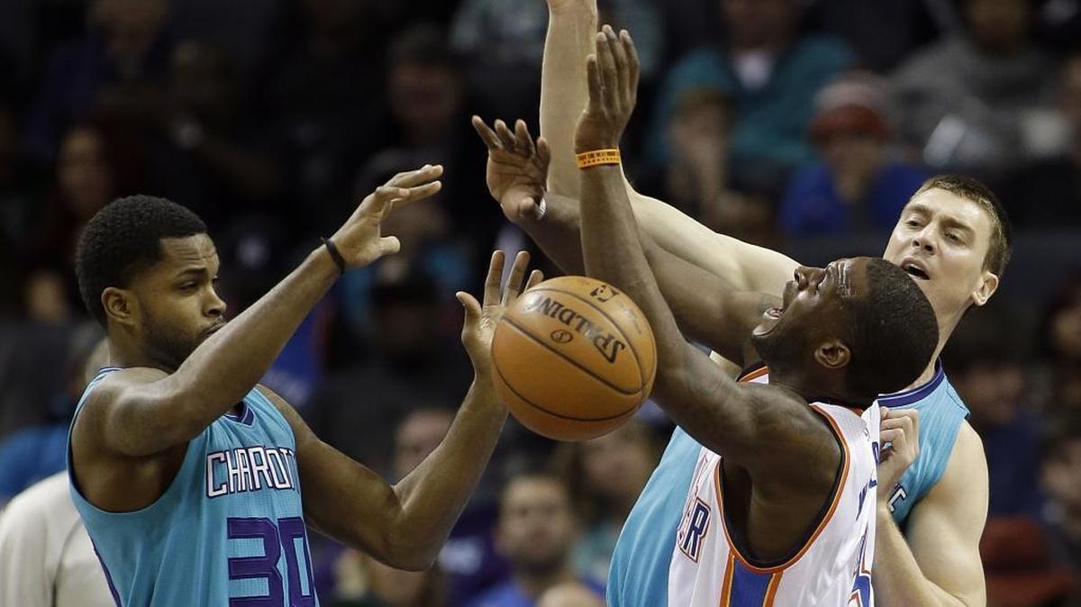 Charlotte Hornets' Troy Daniels, left and Tyler Hansbrough, right, battle Oklahoma City Thunder's Dion Waiters, center, for the ball during the first half of Saturday’s game in Charlotte.