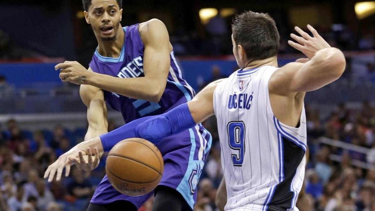 Charlotte Hornets guard Jeremy Lamb, left, passes the ball past Orlando Magic center Nikola Vucevic (9) during the first half of Wednesday’s game in Orlando.