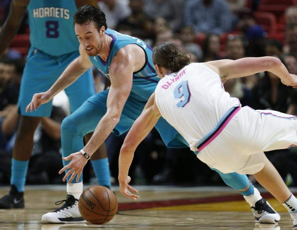 Charlotte Hornets forward Frank Kaminsky III, left, and Miami Heat forward Kelly Olynyk (9) battle for the ball during the first half of Saturday’s game.
