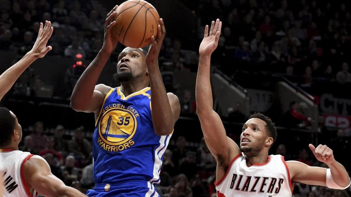 In his first season with Golden State, forward Kevin Durant (center) averages 26.3 points to lead the Warriors.