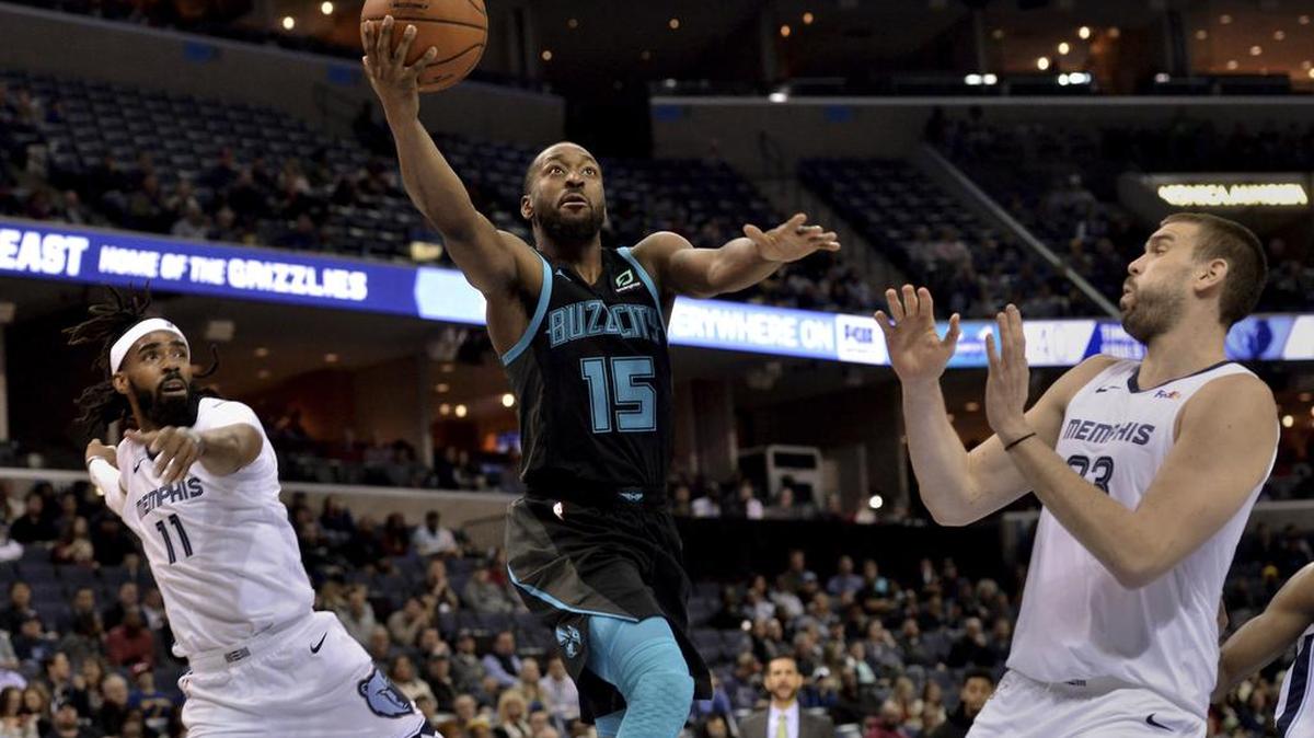 Charlotte Hornets guard Kemba Walker, center, shoots between Memphis Grizzlies guard Mike Conley, left, and center Marc Gasol in the first half of Wednesday night’s NBA game in Memphis. Walker scored 22 points in the Hornets’ 118-107 victory.