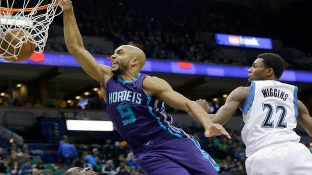 
Charlotte Hornets guard Gerald Henderson (9) dunks against Minnesota Timberwolves forward Andrew Wiggins (22) and Timberwolves center Gorgui Dieng, left, of Senegal, during the first half of an NBA basketball game in Minneapolis, Sunday, March 22, 2015. 

