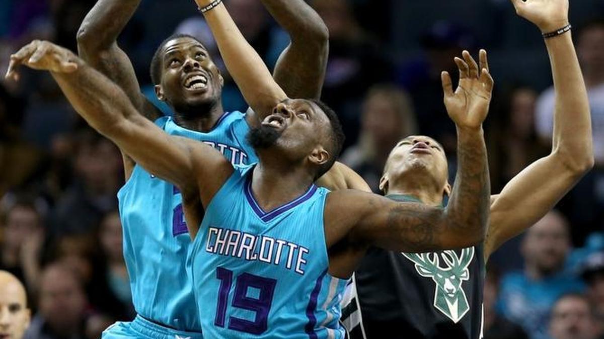 Charlotte Hornets’ Marvin Williams, left, and P.J. Hairston, center, go after a loose ball in Saturday night’s game against the Milwaukee Bucks.