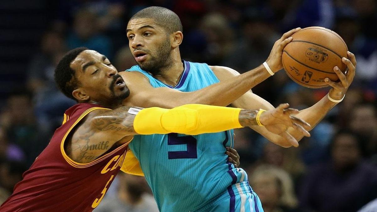 Charlotte Hornets’ Nicolas Batum tries to keep the ball away from the Cleveland Cavaliers’ J.R. Smith during Friday’s game at Time Warner Cable Arena.