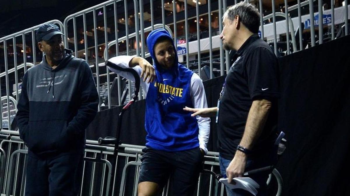 Golden State Warriors guard Stephen Curry, center, and his father, Dell, chat with reporter Steve Goldberg Wednesday morning at the Spectrum Center. Curry sprained his right ankle Monday night at New Orleans and was expected to miss Wednesday’s game against his hometown Charlotte Hornets.
