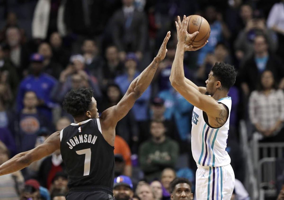 Charlotte Hornets guard Jeremy Lamb, right, shoots the eventual game-winning shot over the Detroit Pistons' Stanley Johnson (7) in Wednesday’s NBA game at Spectrum Center.