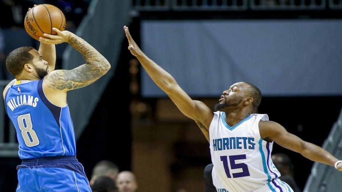 Charlotte Hornets guard Kemba Walker (15) defends a jump shot by Dallas Mavericks guard Deron Williams.