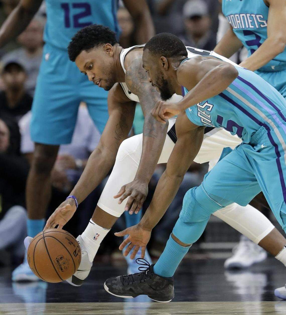 San Antonio Spurs forward Rudy Gay, left, and Charlotte Hornets guard Kemba Walker, right, scramble for a loose ball during the first half of Friday’s game. Walker made just four of his 12 shots, finishing with 13 points.