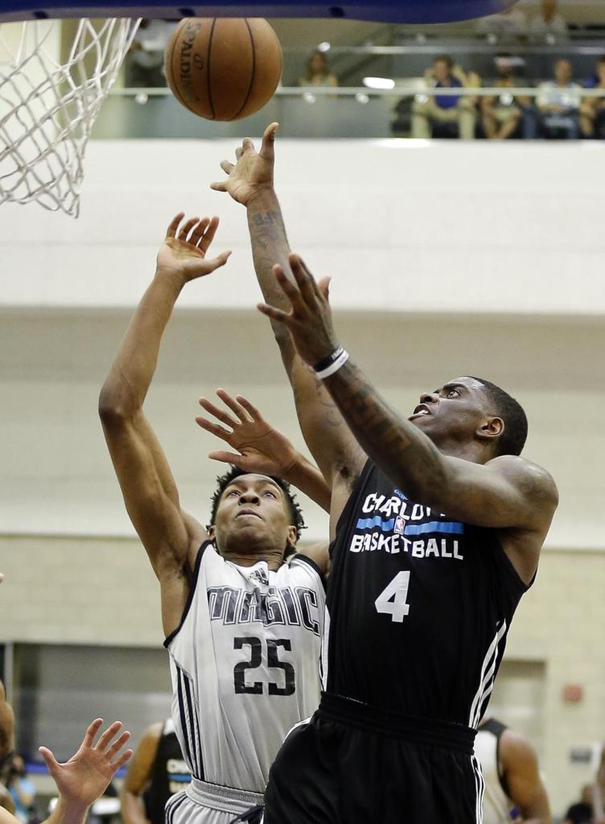 Charlotte Hornets rookie Dwayne Bacon (4) takes a shot over Orlando Magic's Wesley Iwundu (25) in Thursday’s game at the Orlando Summer League.