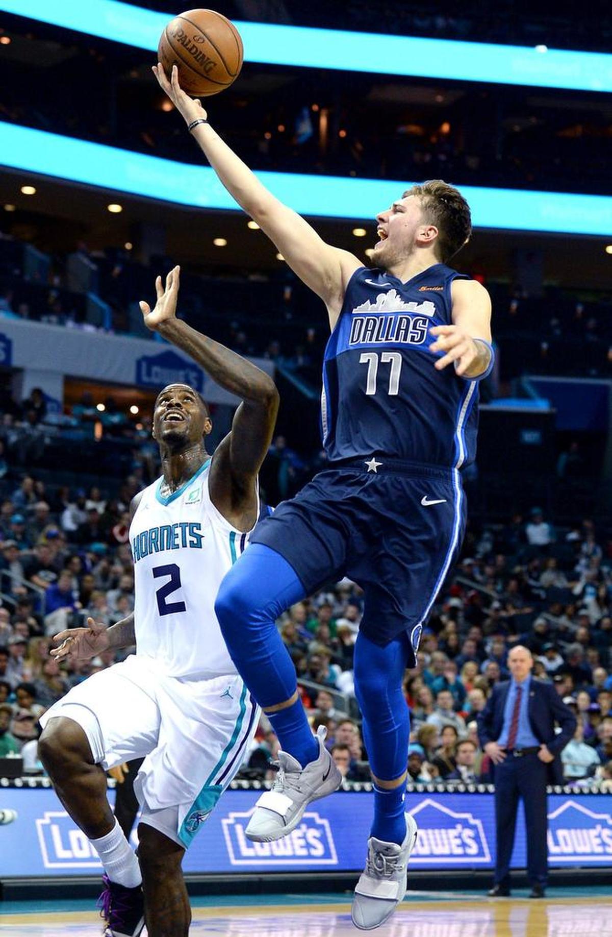 Dallas Mavericks guard/forward Luka Doncic, right, drives to the basket for two-points as Charlotte Hornets forward Marvin Williams looks on during second half of Wednesday’s NBA game at Spectrum Center.