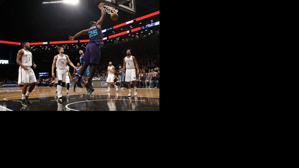 
Brooklyn Nets' Joe Johnson (7), Brook Lopez (11) and Alan Anderson (6) watch as Charlotte Hornets' Al Jefferson (25) dunks the ball during the first half of an NBA basketball game Wednesday, March 4, 2015, in New York. 
