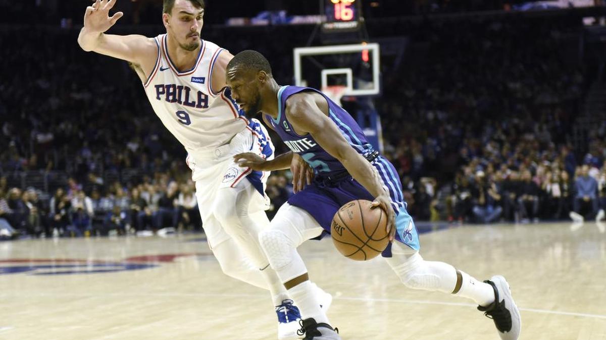 Charlotte Hornets guard Kemba Walker, right, drives to the basket as the Philadelphia 76ers’ Dario Saric defends during Saturday night’s NBA game in Philadelphia.