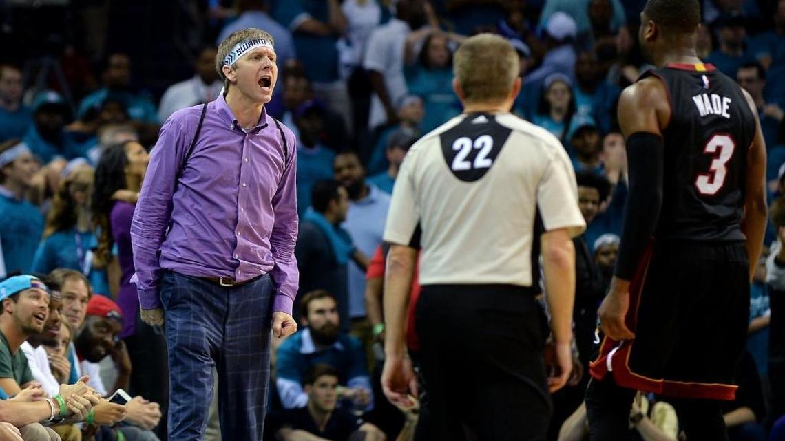 Miami Heat guard Dwyane Wade, right, stares back at Charlotte Hornets fan Michael Deason, also now known as the “purple-shirt guy” after yelling at Wade during the fourth quarter in Game 6 on Friday.