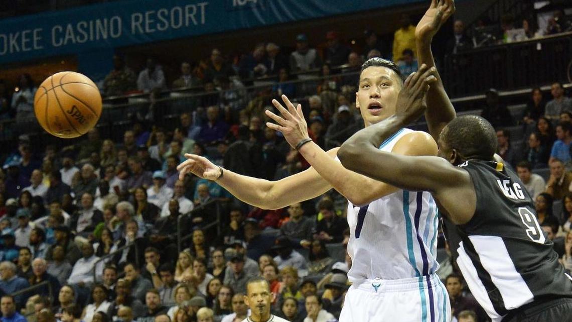 Charlotte Hornets Jeremy Lin on left, passes the ball away from Miami Heat's Luol Deng on right, during Wednesday night's game played at Time Warner Cable Arena, Dec 9, 2015. The Charlotte Hornets defeated the Miami heat 99-81.