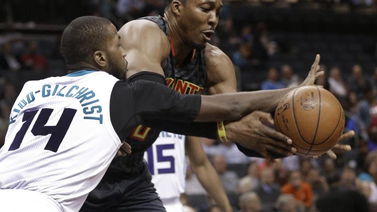 The Atlanta Hawks’ Dwight Howard, right, and the Charlotte Hornets’ Michael Kidd-Gilchrist chase a loose ball during a game in March at the Spectrum Center in Charlotte. According to reports, Howard will join the Hornets in a deal with the Hawks.