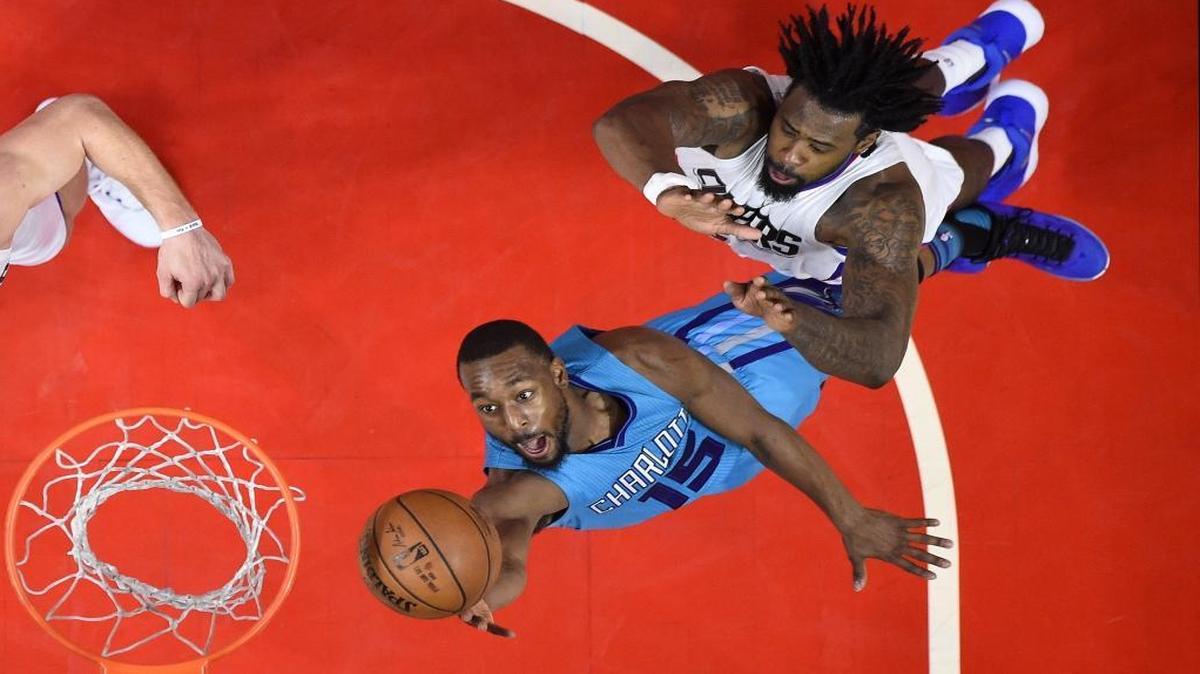 Charlotte Hornets guard Kemba Walker, left, shoots as Los Angeles Clippers center DeAndre Jordan defends during the second half of Sunday’s game. The Clippers won 124-121 in overtime.