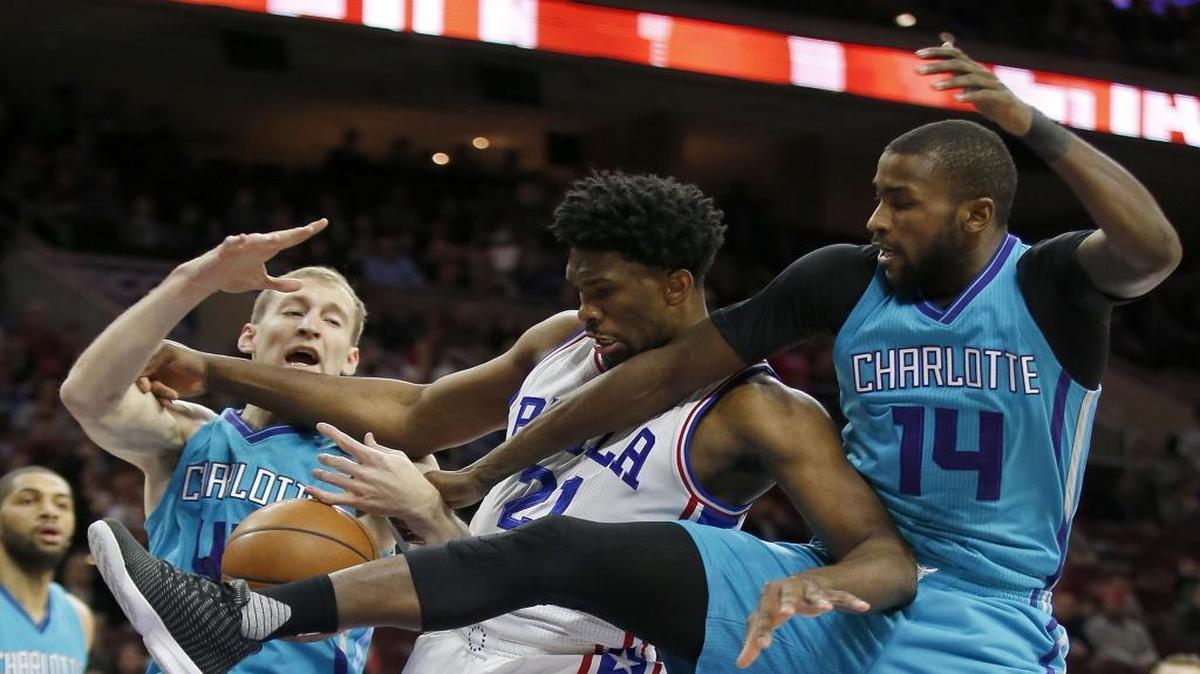 The Philadelphia 76ers' Joel Embiid (21) battles for the ball against the Charlotte Hornets' Cody Zeller, left, and Michael Kidd-Gilchrist (14) on Friday.