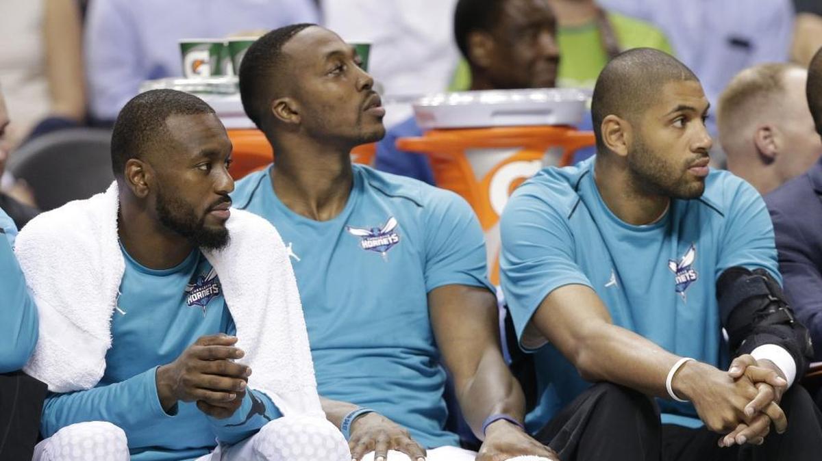 Nic Batum (right, with brace on his left elbow) has yet to play this regular season, but he’s never far from teammates and on schedule for a return to active roster soon.