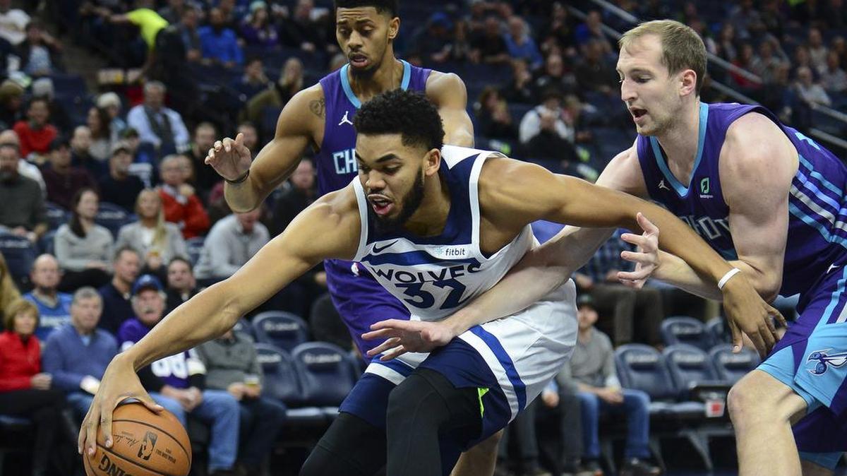 The Minnesota Timberwolves’ Karl-Anthony Towns, center, chases a rebound against Charlotte Hornets center Cody Zeller, right, during Wednesday night’s NBA game in Minneapolis, Minn. Towns scored 35 points and tied a career high with six blocks and added 12 rebounds in the Timberwolves’ 121-104 win.