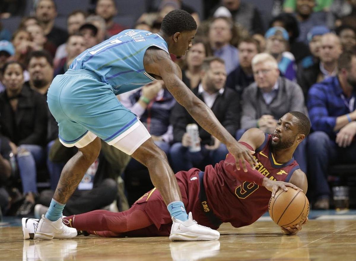 Cleveland Cavaliers guard Dwyane Wade, right, looks to pass the ball as Charlotte Hornets rookie Dwayne Bacon defends in the first half of Wednesday’s NBA game at the Spectrum Center.