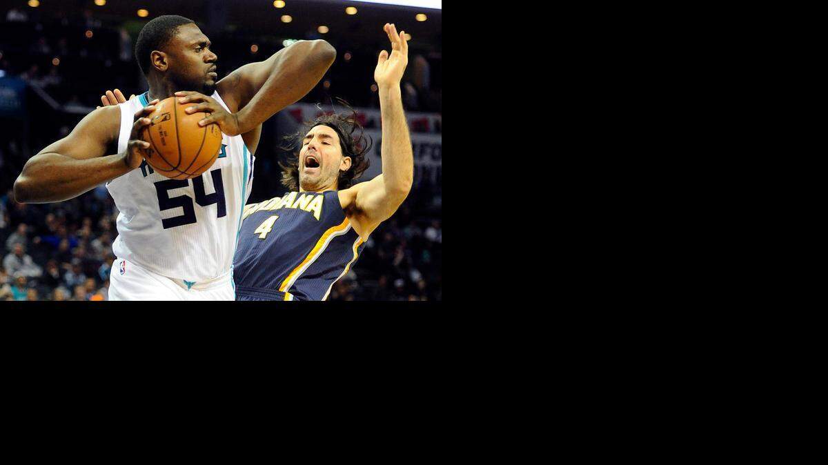 
Charlotte Hornets' Jason Maxiell (54) claims a rebound as Indiana Pacers' Luis Scola (4) falls backward in the first half at Time Warner Cable Arena on Feb. 8, 2015. 
