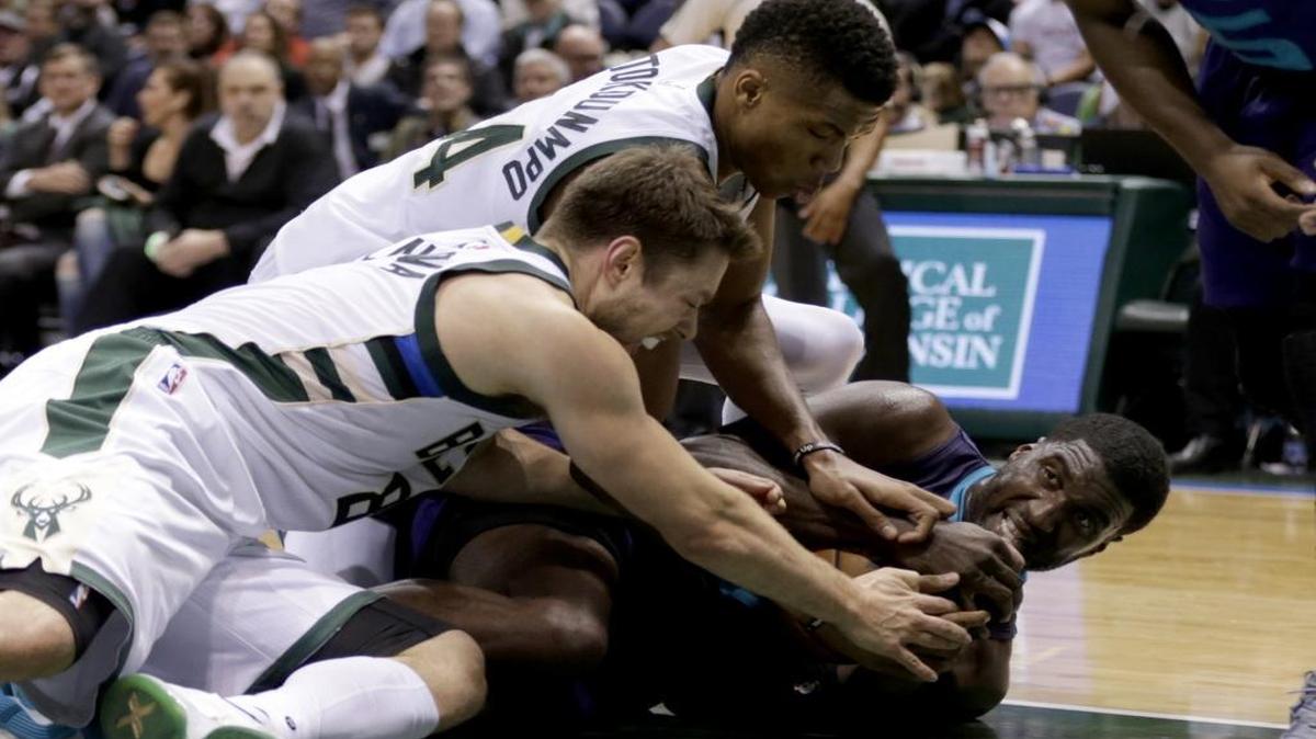 Charlotte Hornets center Roy Hibbert, right, fights the Milwaukee Bucks’ Giannis Antetokounmpo and Matthew Dellavedova for a loose ball during the third quarter of Wednesday’s game in Milwaukee.