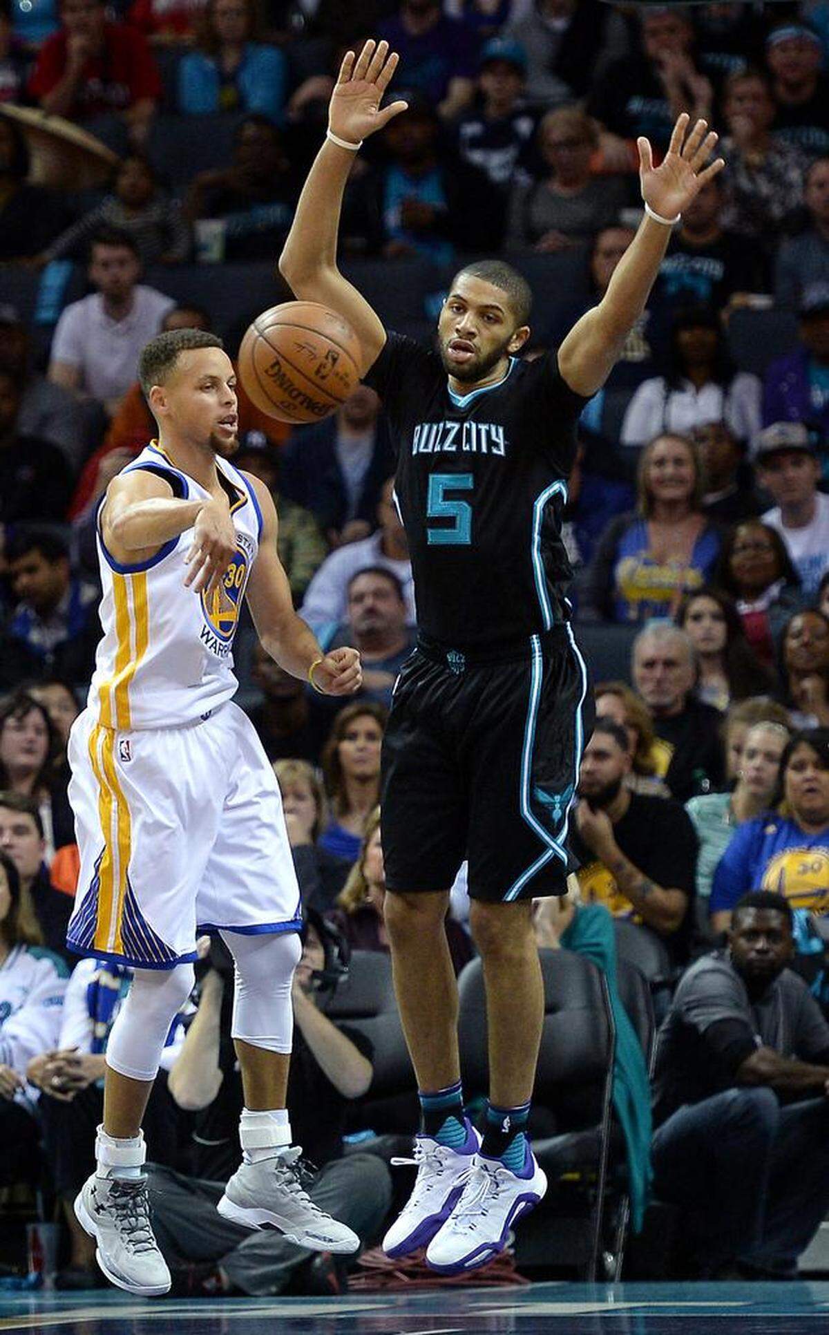 Golden State Warriors guard Stephen Curry (left) passes the ball to a teammate as Charlotte’s Nic Batum defends during a 2015 game. Hornets guard Nicolas Batum, right, looks on during first half action at Time Warner Cable Arena in Charlotte, NC on Wednesday, December 2, 2015. The Warriors defeated the Hornets 116-99.ds a