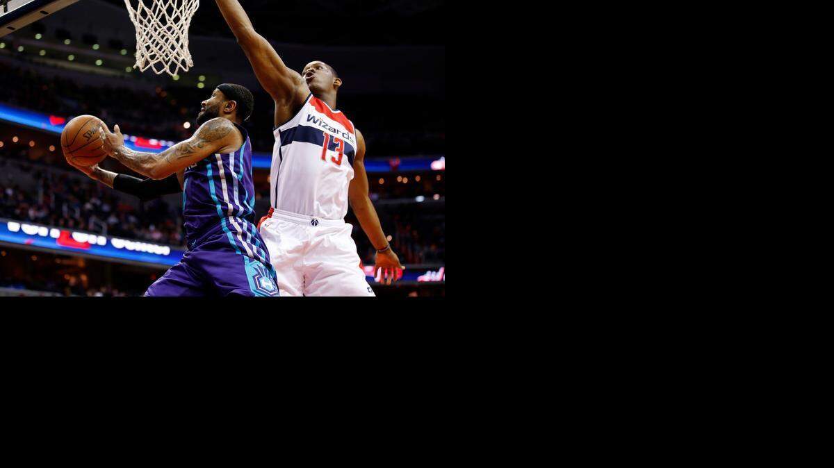 
Charlotte Hornets guard Mo Williams (7) shoots past Washington Wizards center Kevin Seraphin (13), from France, in the first half of an NBA basketball game Friday, March 27, 2015, in Washington.
