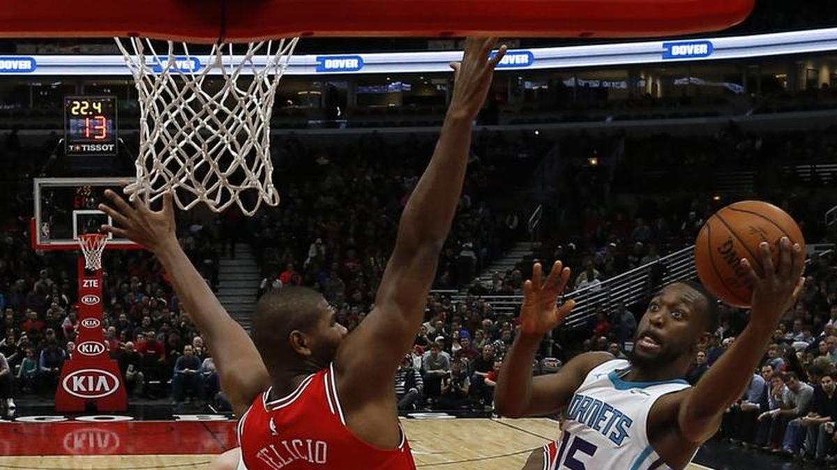 Charlotte Hornets' Kemba Walker, right, goes to the basket against Chicago Bulls' Cristiano Felicio during the first half of Friday’s NBA game in Chicago.