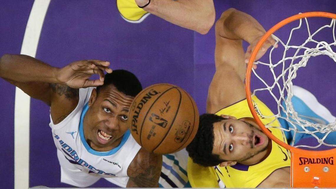 Charlotte Hornets guard Treveon Graham, left, and Los Angeles Lakers guard Josh Hart reach for a rebound during the first half of Friday’s game. The Hornets won 108-94 Friday to wrap up a California road trip with three wins in four games.
