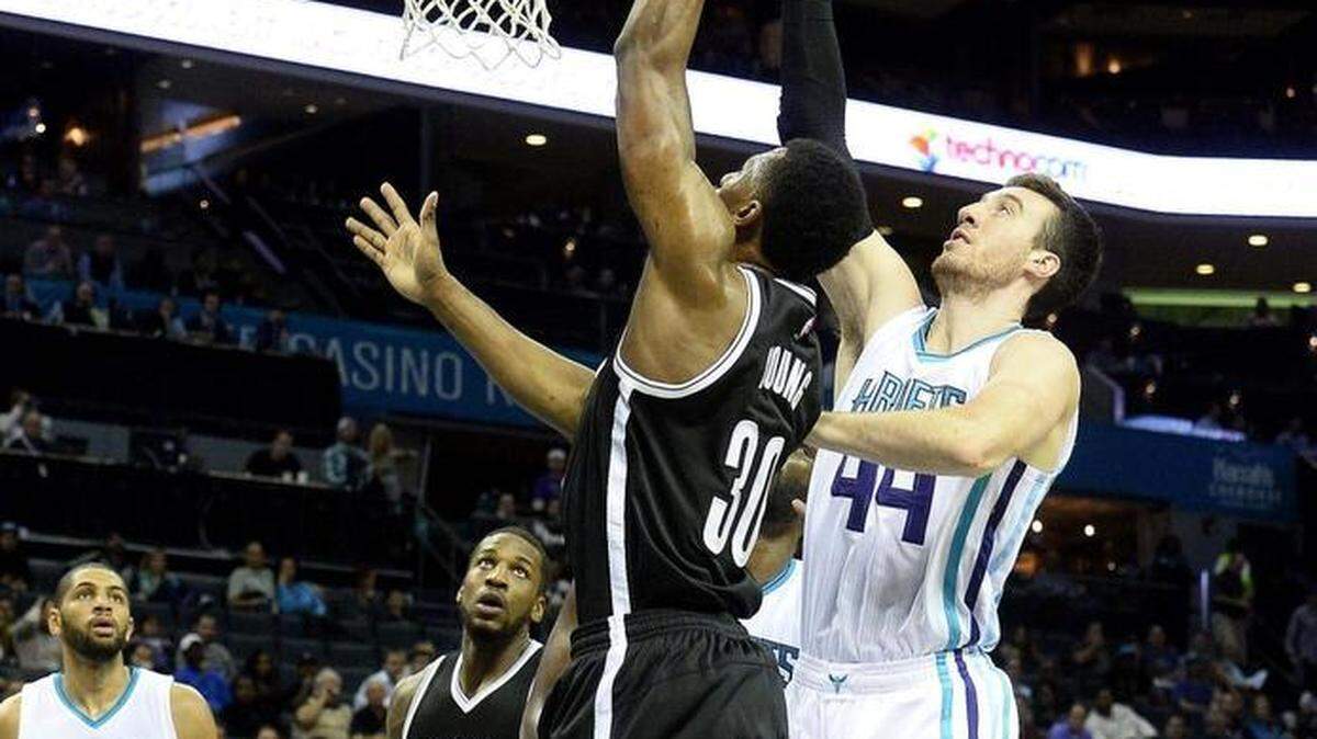 The Nets’ Thaddeus Young (30) and the Hornets’ Frank Kaminsky reach for a rebound during the first half Wednesday in Charlotte.