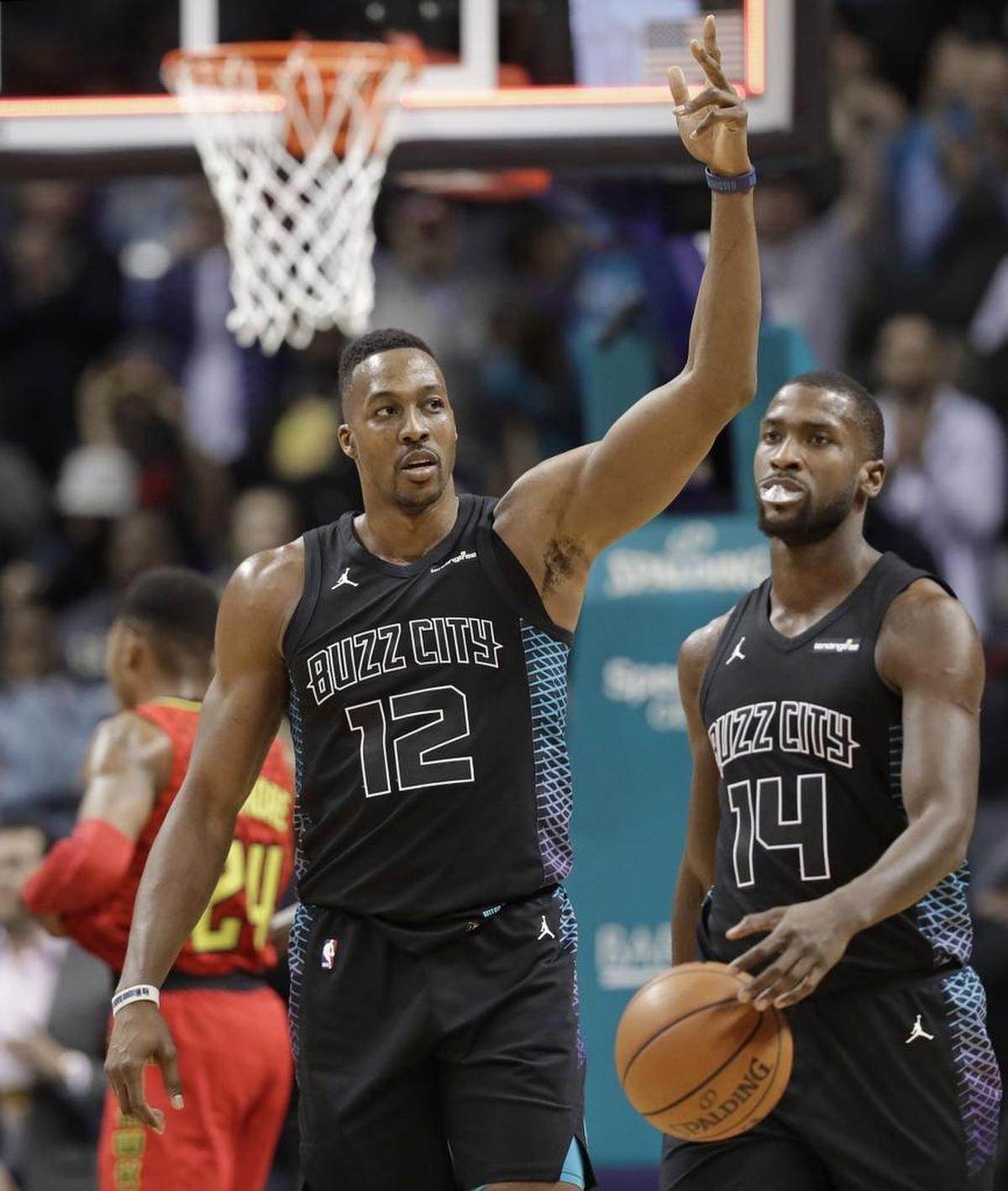 Charlotte Hornets' Dwight Howard (left) celebrates alongside teammate Michael Kidd-Gilchrist after the Hornets’ 121-110 win over the Atlanta Hawks Friday.