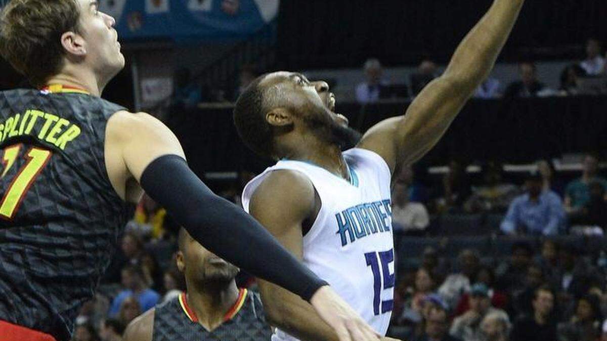 Charlotte Hornets Kemba Walker, right, scores during Wednesday night's game at Time Warner Cable Arena.