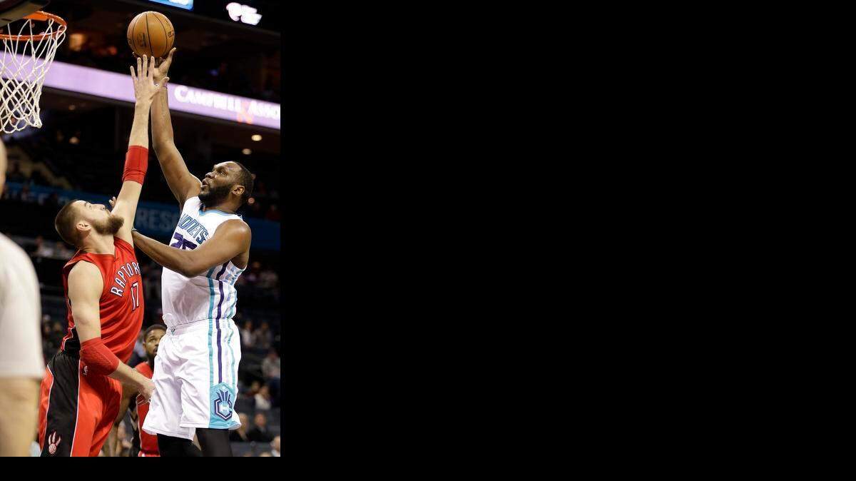 
The Hornets’ Al Jefferson (right) gets his shot off over Toronto’s Jonas Valanciunas during the first half of an NBA game in Charlotte on Friday, March 6, 2015. 
