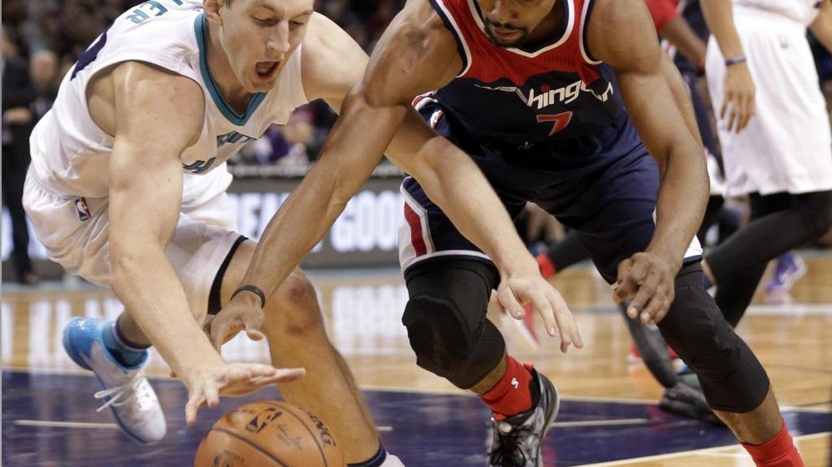 Washington Wizards' Ramon Sessions, right, and Charlotte Hornets' Cody Zeller, left, chase a loose ball in the first half of Wednesday’s game in Charlotte.