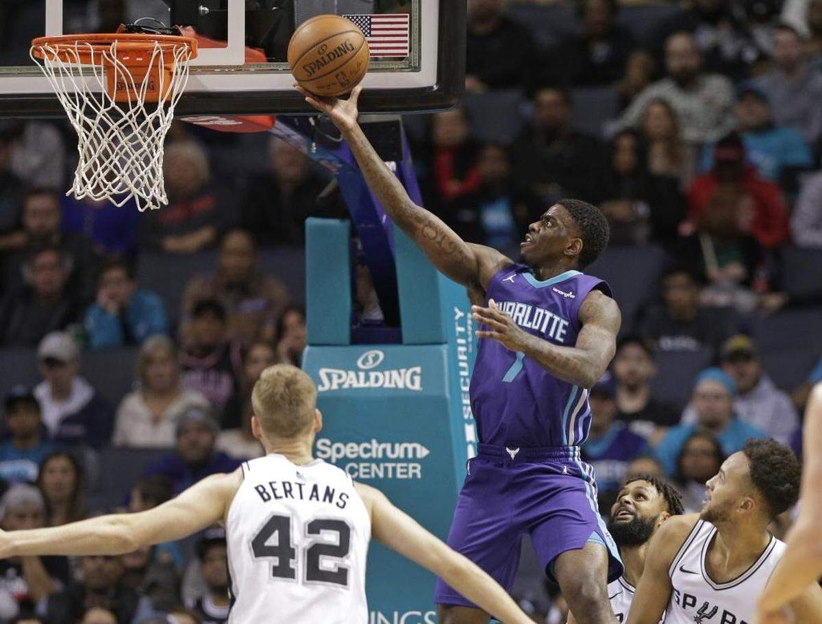 Charlotte Hornets' Dwayne Bacon (7) drives to the basket past San Antonio Spurs' Davis Bertans (42) during the first half of Saturday’s game.