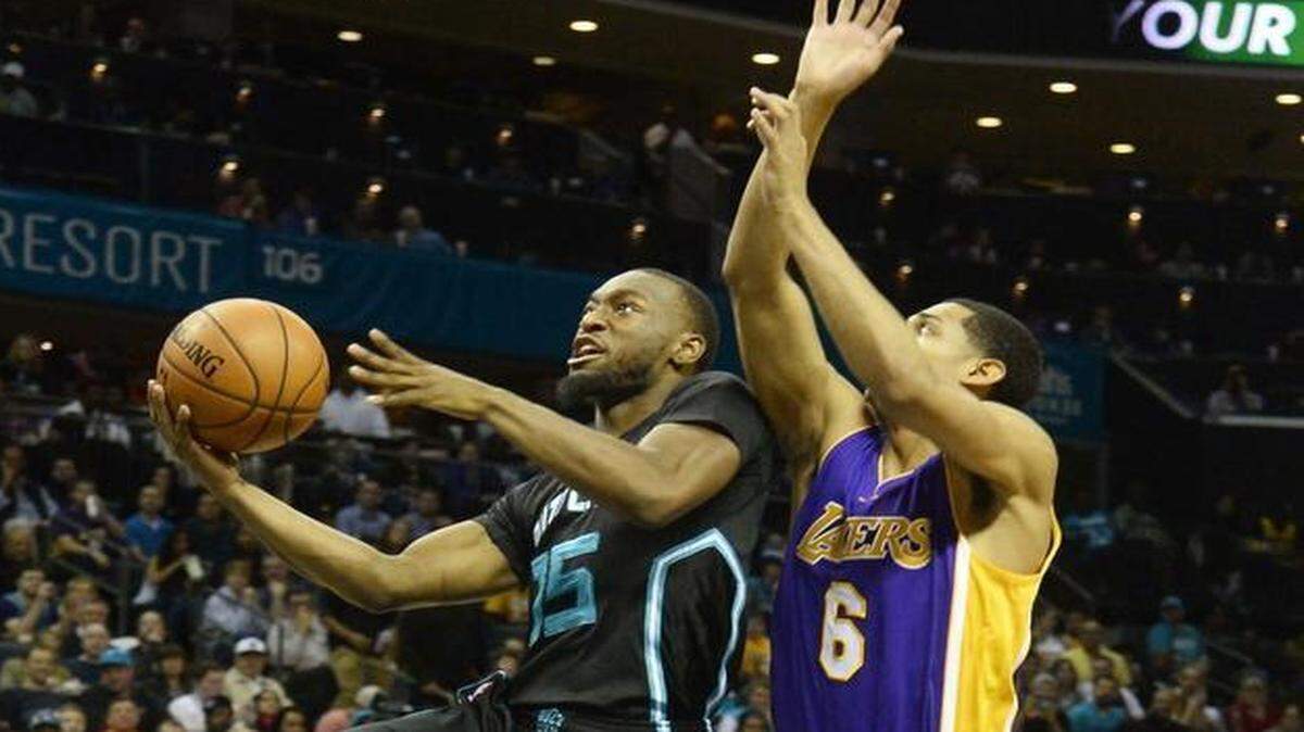 From left, Charlotte Hornets Kemba Walker drives the ball to the basket to score against Los Angeles Lakers Jordan Clarkson during Monday night's game played at Time Warner Cable Arena, Dec. 28, 2015. The Hornets won 108-98.