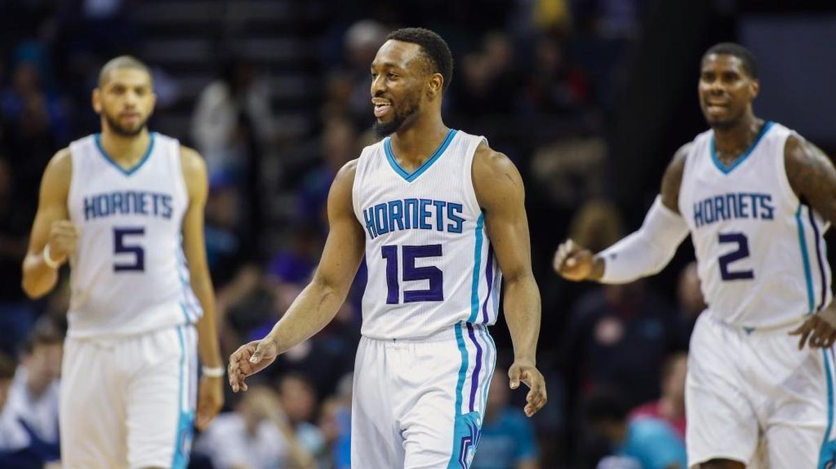 Charlotte Hornets guard Kemba Walker, center, smiles as teammates Nicolas Batum, left and Marvin Williams look on after Walker hit a 3-pointer in the closing seconds against the New Orleans Pelicans in the second half of Wednesday’s game. Charlotte won 122-113.