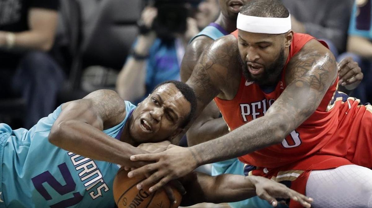 Charlotte Hornets' Treveon Graham (21) and New Orleans Pelicans' DeMarcus Cousins (0) battle for a loose ball during the first half of Wednesday’s game at Spectrum Center.
