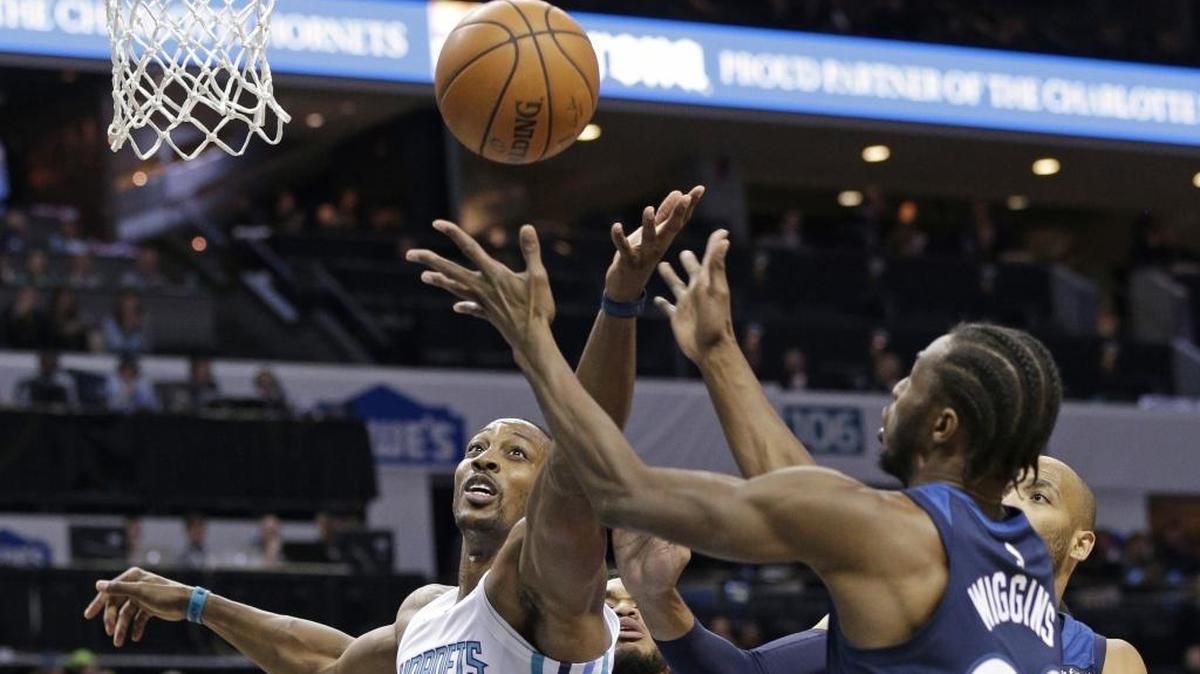 Charlotte Hornets' Dwight Howard (12) and Minnesota Timberwolves' Andrew Wiggins (22) battle for a rebound Monday at Spectrum Center.