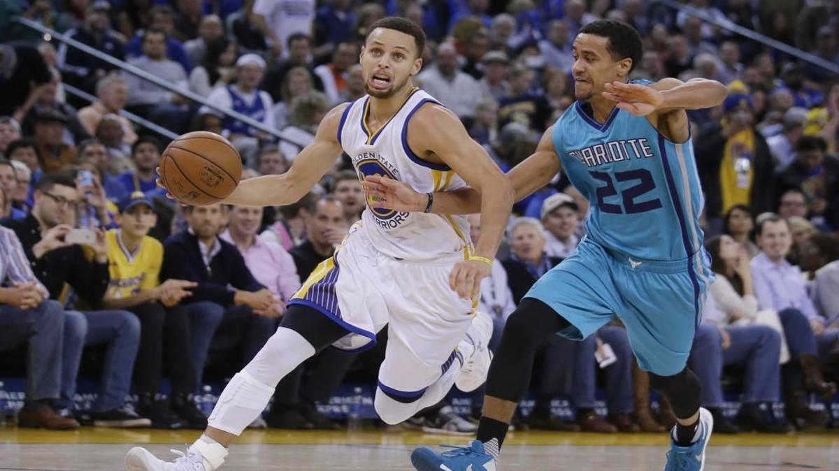 Golden State Warriors' Stephen Curry, left, dribbles past Charlotte Hornets' Brian Roberts (22) during the second half of an NBA basketball game Monday, Jan. 4, 2016, in Oakland, Calif. Golden State won 111-101.