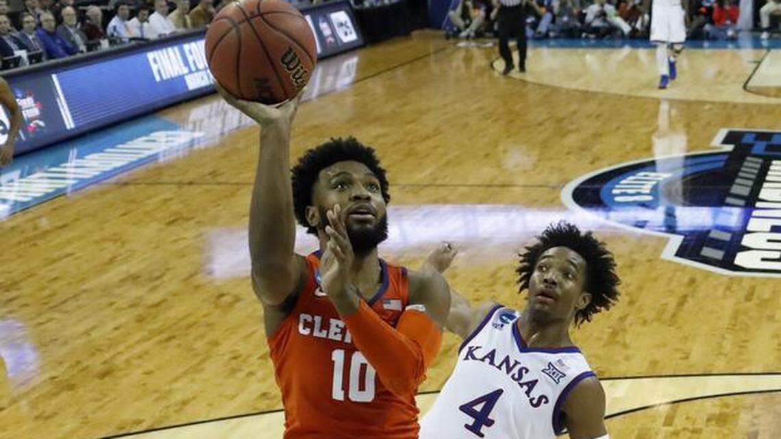 Former Clemson star Gabe DeVoe (left) heads to the basket against Kansas All-American Devonte' Graham during an NCAA regional semifinal last March in Omaha, Neb. DeVoe and Graham are now both on the Charlotte Hornets’ summer-league roster.