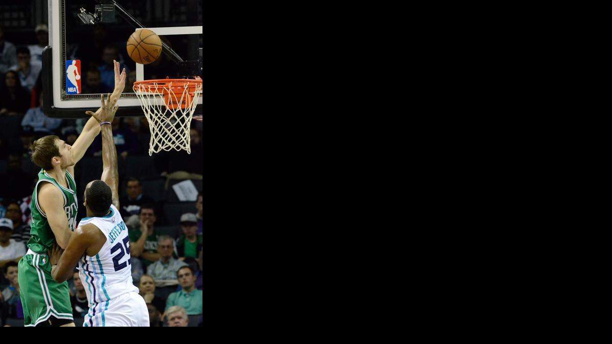 
 Boston Celtics Tyler Zeller (44) (left), tips the ball into he basket over Charlotte Hornets Al Jefferson (25), during Monday's game played against the Boston Celtics at Time Warner Cable Arena .
