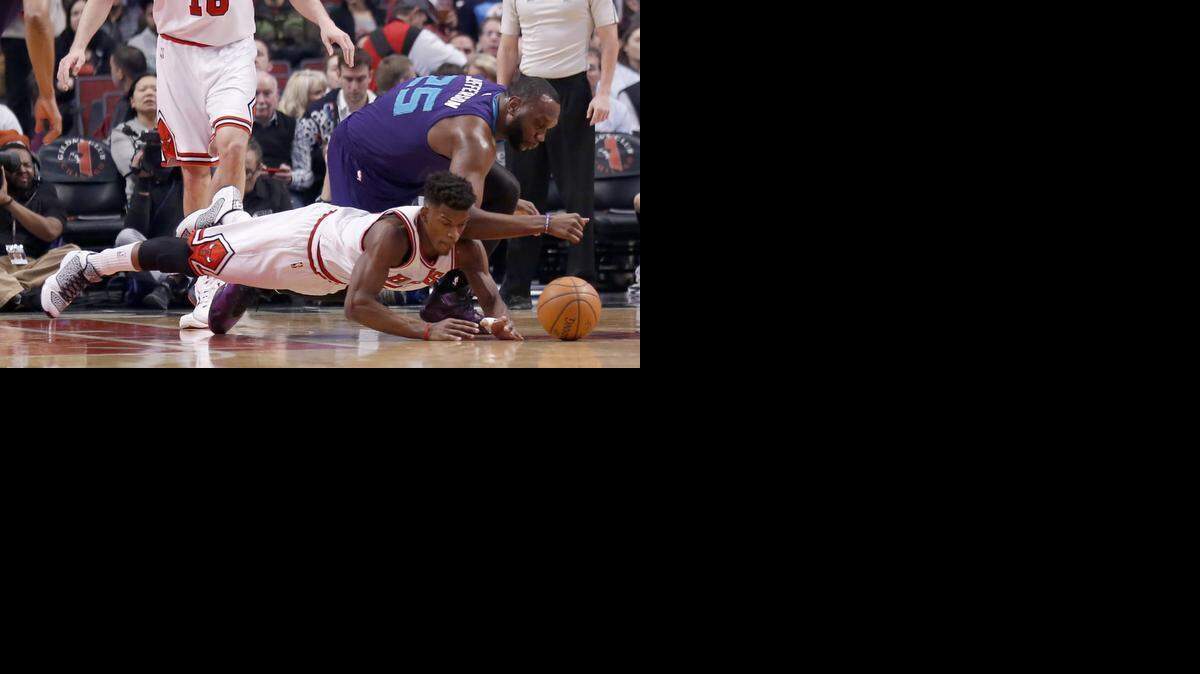 
Chicago Bulls guard Jimmy Butler, bottom, and Charlotte Hornets center Al Jefferson go after a loose ball during the first half of an NBA basketball game Wednesday, Feb. 25, 2015, in Chicago. 
