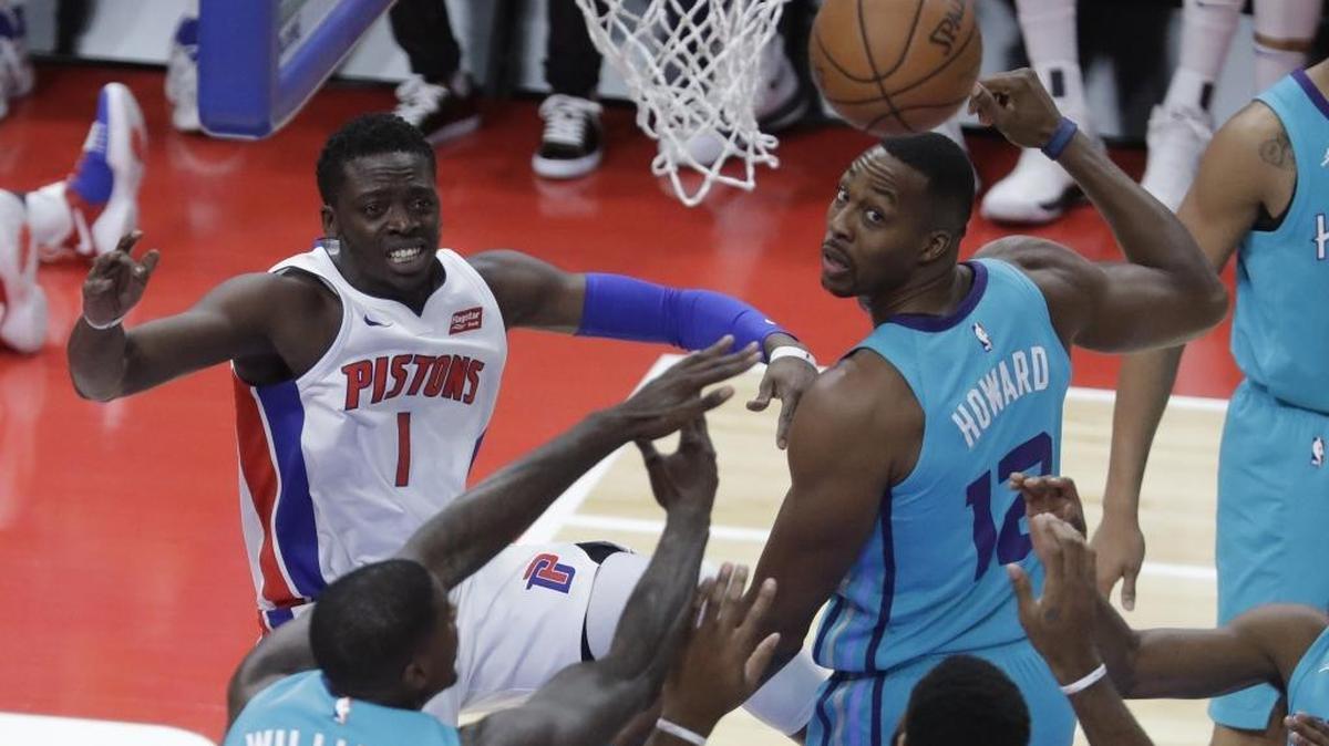 Detroit Pistons guard Reggie Jackson (1) passes the ball while defended by Charlotte Hornets center Dwight Howard (12) and forward Marvin Williams during the first half of Wednesday’s NBA game in Detroit.