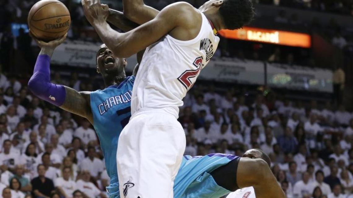 Charlotte Hornets forward Marvin Williams, front left, goes to the basket as Miami Heat center Hassan Whiteside (21) defends during the first half of Game 1 of a first-round NBA basketball playoff series Sunday in Miami.