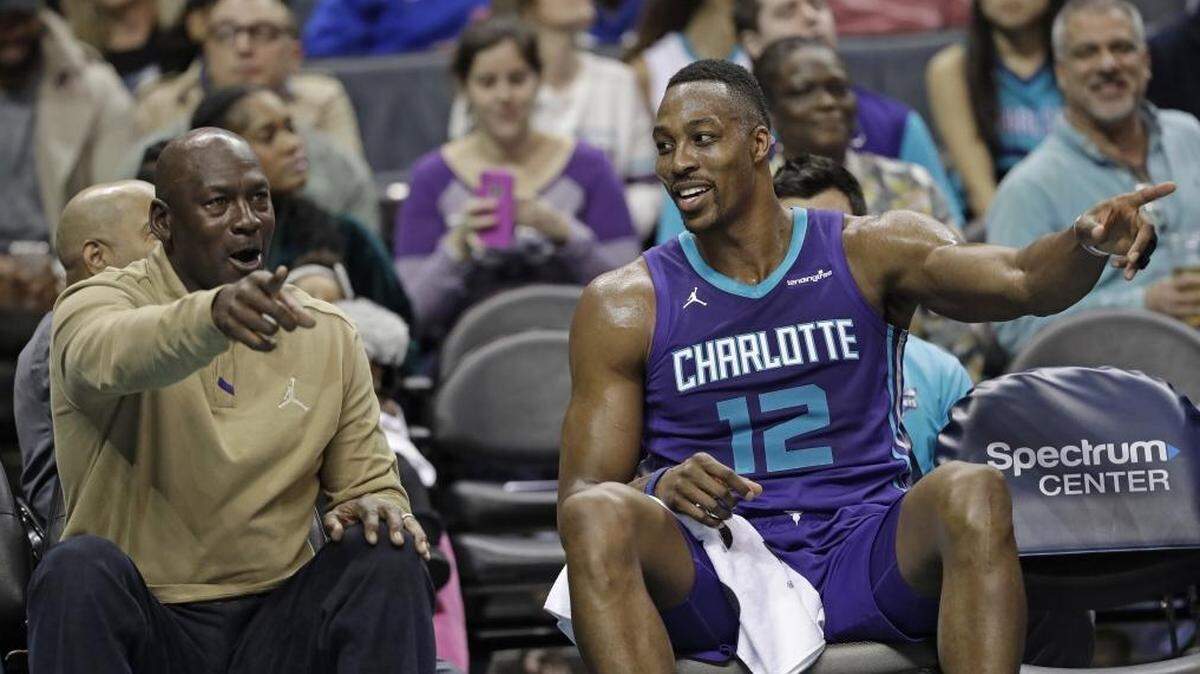 Charlotte Hornets owner Michael Jordan, left, talks with Dwight Howard, right, during the first half of Friday’s game at Spectrum Center. The Hornets beat the Jazz, 99-88.