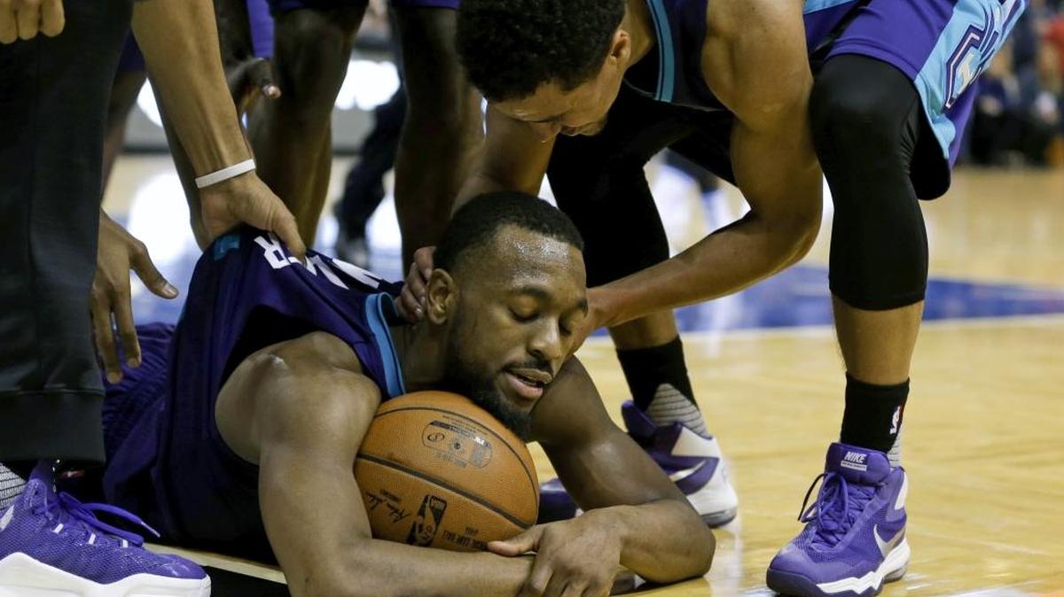Charlotte Hornets guard Kemba Walker lies on the floor after grabbing a loose ball and calling a timeout against the Orlando Magic on Friday.