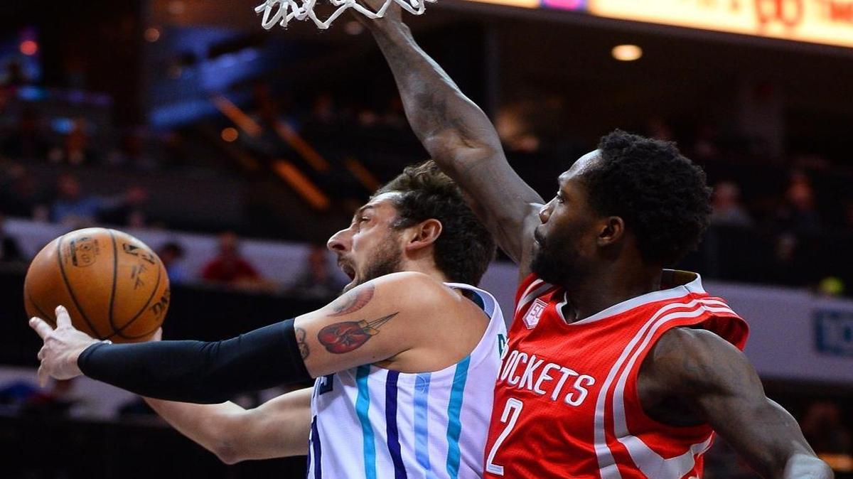 Hornets’ Marco Belinelli, left, drives to the basket as Rockets’ Patrick Beverly applies pressure. Committing a season-high 22 turnovers, the Hornets fell to the Rockets 107-95.